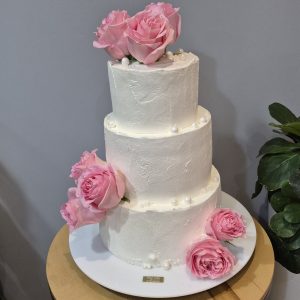 Tort de nuntă cu trei nivele, acoperit în cremă cheese și decorat cu flori vii roz, Emys Cakes