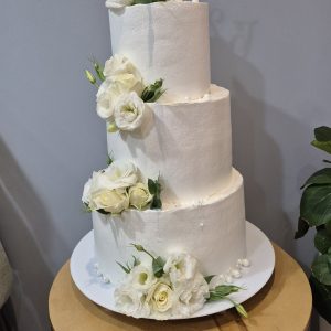 Tort de nuntă cu trei nivele, decorat cu flori vii trandafiri și eustome albe, cremă cheese, Emys Cakes