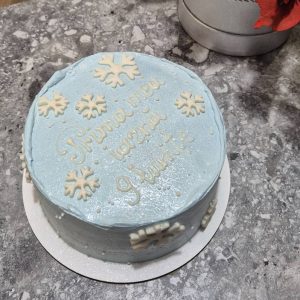 Tort albastru deschis cu fulgi de nea albi și mesaj „Prima mea iarnă, 9 luni”