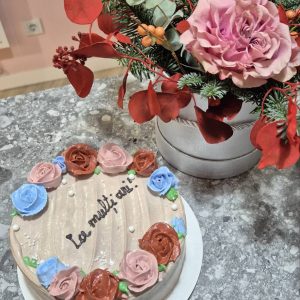 Tort crem „La mulți ani” cu trandafiri din cremă în nuanțe de roz, roșu și albastru