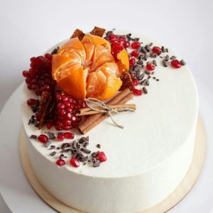 Tort alb cu mandarină, rodie, scorțișoară și fulgi de ciocolată pe deasupra