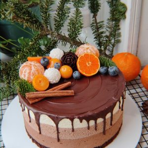 Tort mousse cu trei straturi de ciocolată, glazură de ciocolată și decor cu mandarine, afine, bomboane Raffaello și scorțișoară