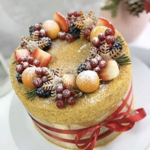 Tort cu biscuiți și fructe de pădure, decorat în coroana de iarnă cu panglică roșie