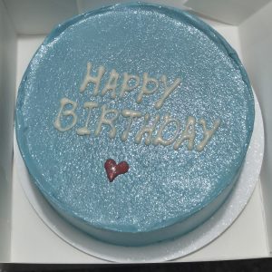 Tort bento albastru sidefat, cu mesaj „Happy Birthday” și inimioară roșie.