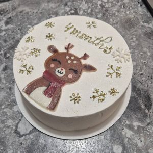 Bento cake alb sidefat cu ren bebeluș și fulgi aurii de zăpadă, decorat cu mesaj „4 months”, realizat de Emys Cakes.