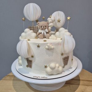 Tort alb elegant cu ursuleț, baloane cu aer cald, nori și steluțe aurii, Emys Cakes