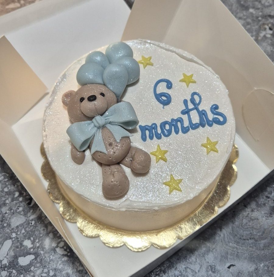 Bento „6 months” cu ursuleț teddy maro cu fundă albastră, baloane albastre, stele galbene pe cremă albă sidefată, auriu bază, în cutie albă, 660-700g de la Emys Cakes