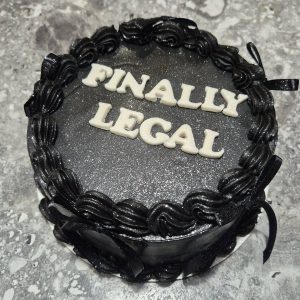 Tort bento negru lucios cu inscripție albă „FINALLY LEGAL” și fundă neagră de la Emys Cakes, perfect pentru majorat sau aniversare 18 ani