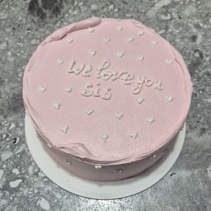 Tort bento roz cu inimioare albe și mesaj „We love you sis”, decor minimalist de la Emys Cakes – cadou perfect pentru soră