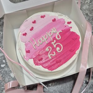 Tort bento cu pictură watercolor roz cu inimioare, text alb „Happy 25” de la Emys Cakes, ambalat în cutie roz cu fundă – aniversare feminină