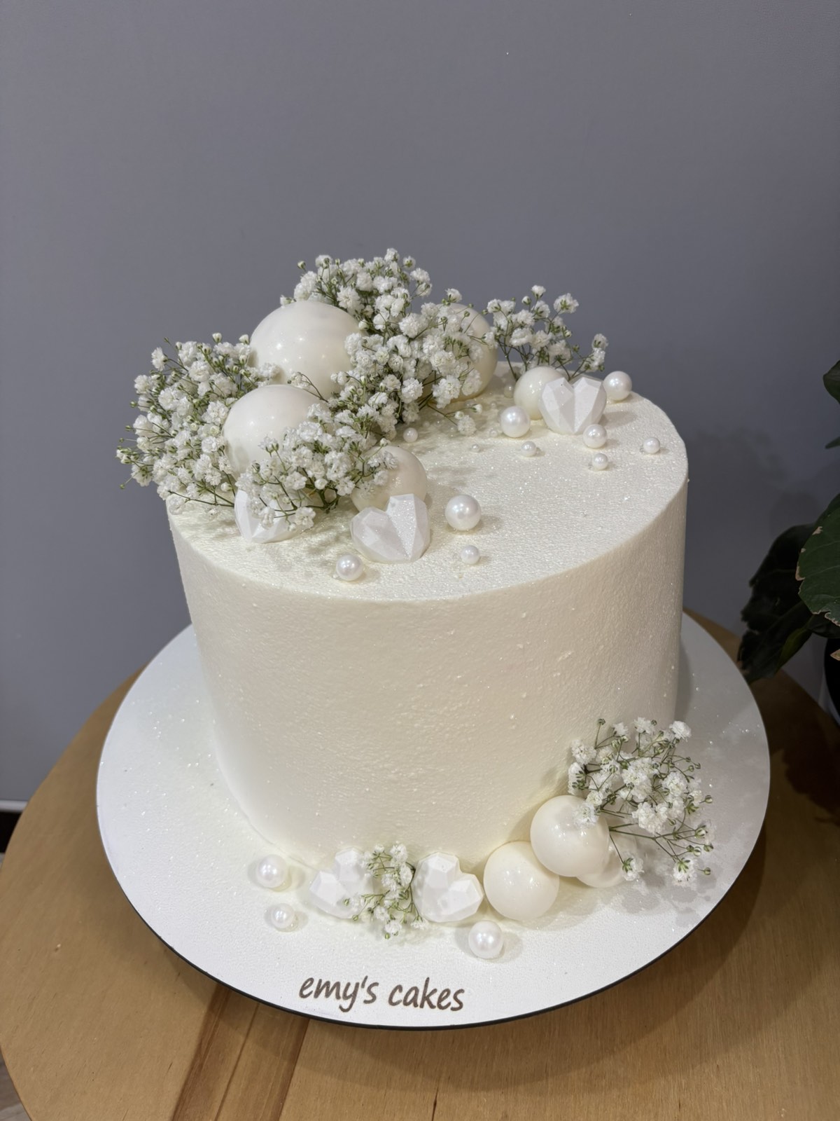 Tort de nuntă alb cu efect de pudră, decorat cu flori gypsophila, perle și globuri elegante, Emys Cakes