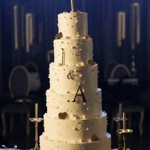 Tort de nuntă alb elegant pe 5 etaje, cu inițiale A&I și accente aurii, acoperit în cremă, Emys Cakes