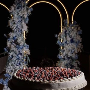 Tort de nuntă alb cu fructe de pădure și blat pe suport închis la culoare, decor elegant pentru eveniment, Emys Cakes