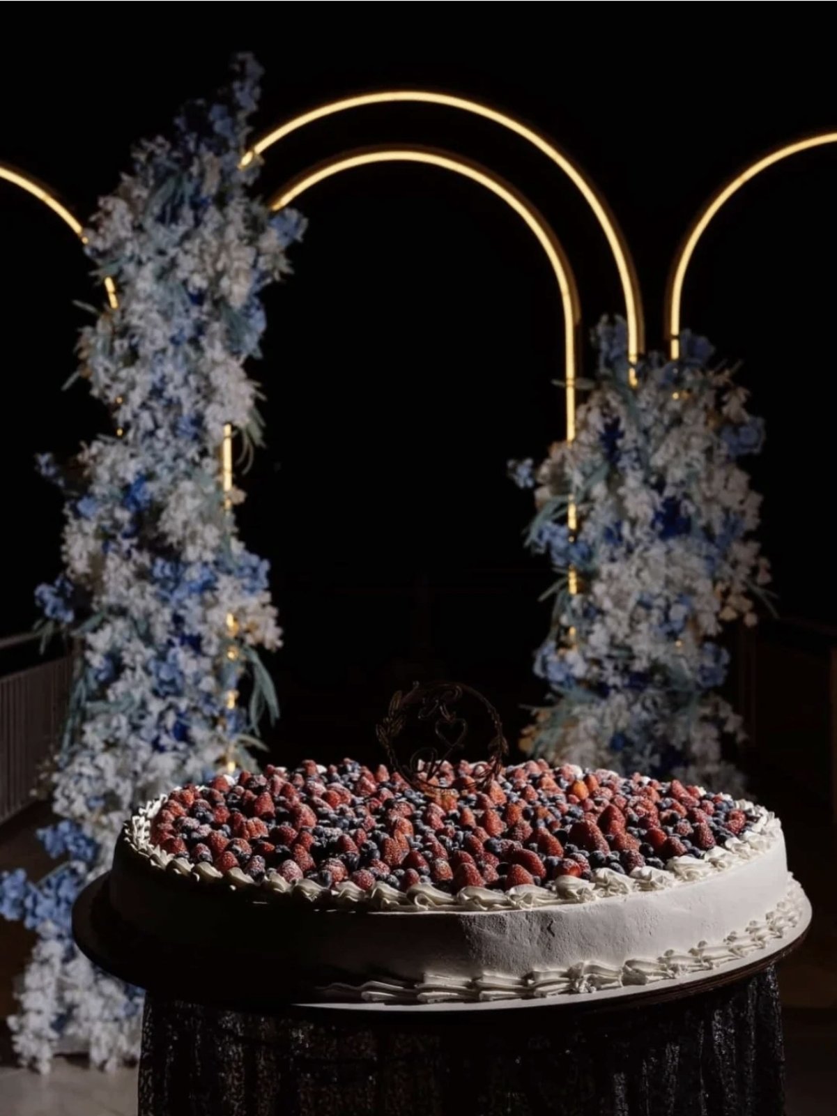 Tort de nuntă alb cu fructe de pădure și blat pe suport închis la culoare, decor elegant pentru eveniment, Emys Cakes