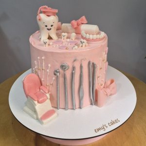 Tort tematic stomatolog roz, acoperit în crem chesse, cu decor din instrumente dentare și un dinte simpatic, Emys Cakes